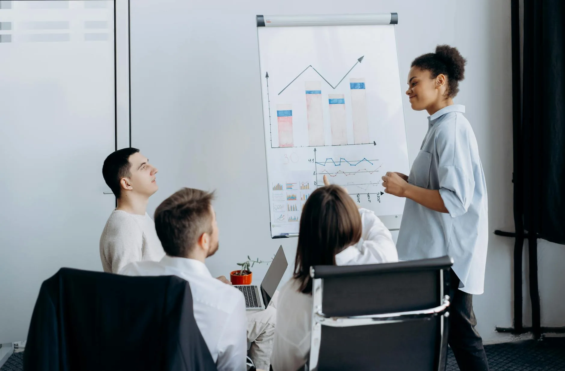 Multicultural team in office brainstorming business strategy with charts.