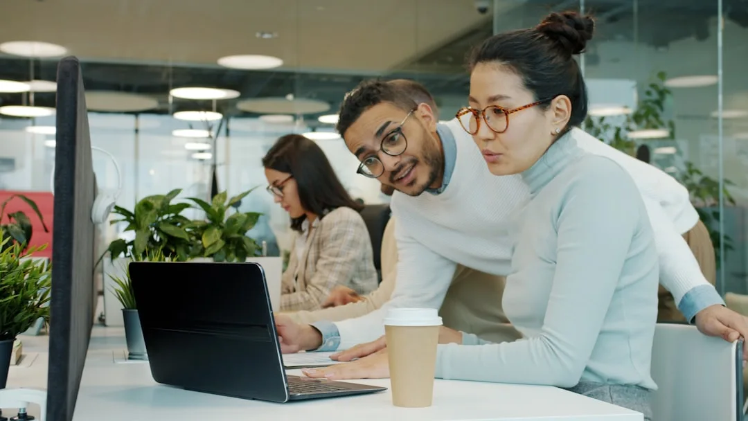 [Unsplash] Two colleagues collaborating on a laptop in office.