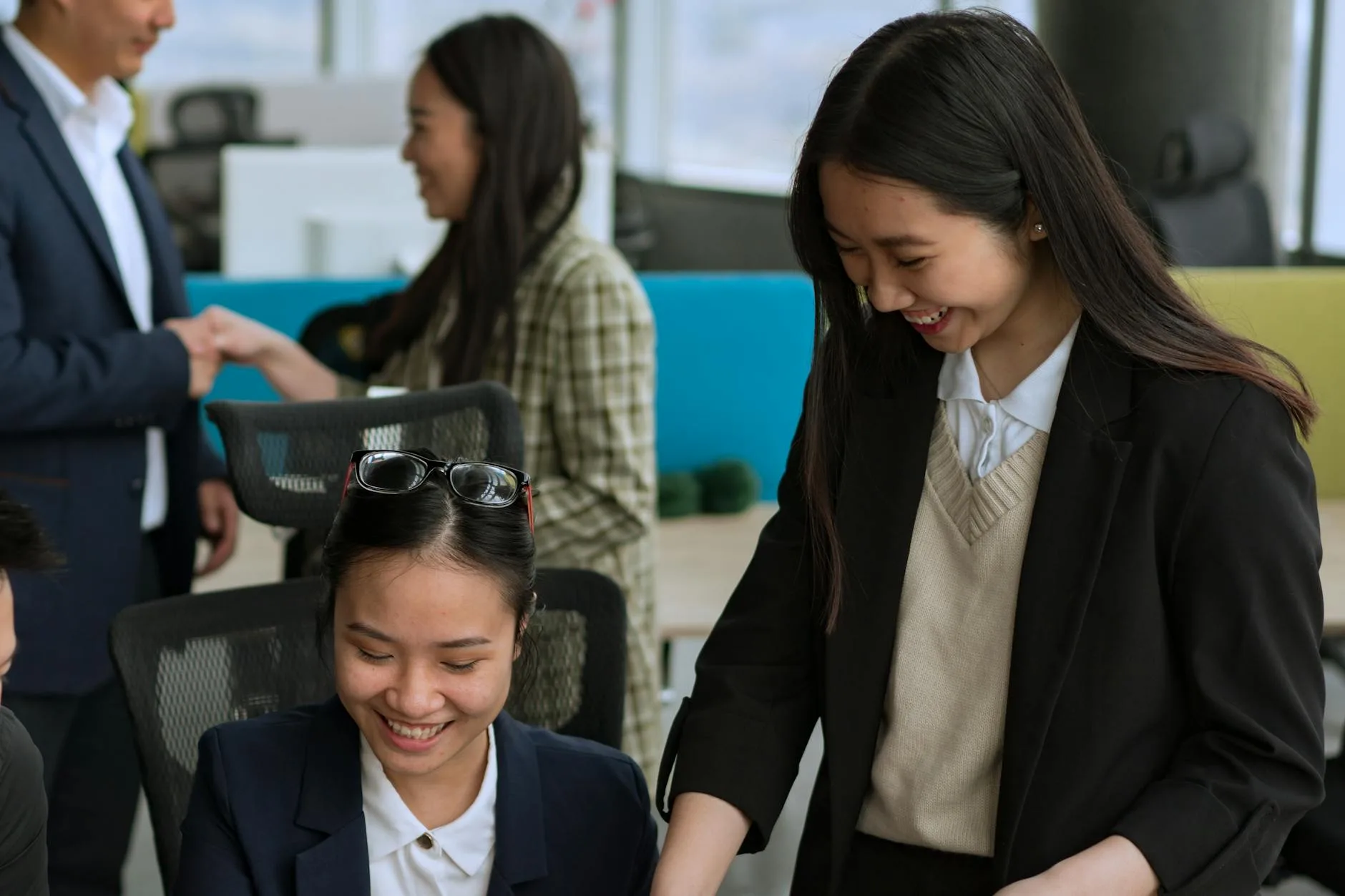 Asian professionals collaborating in a bright modern office setting.