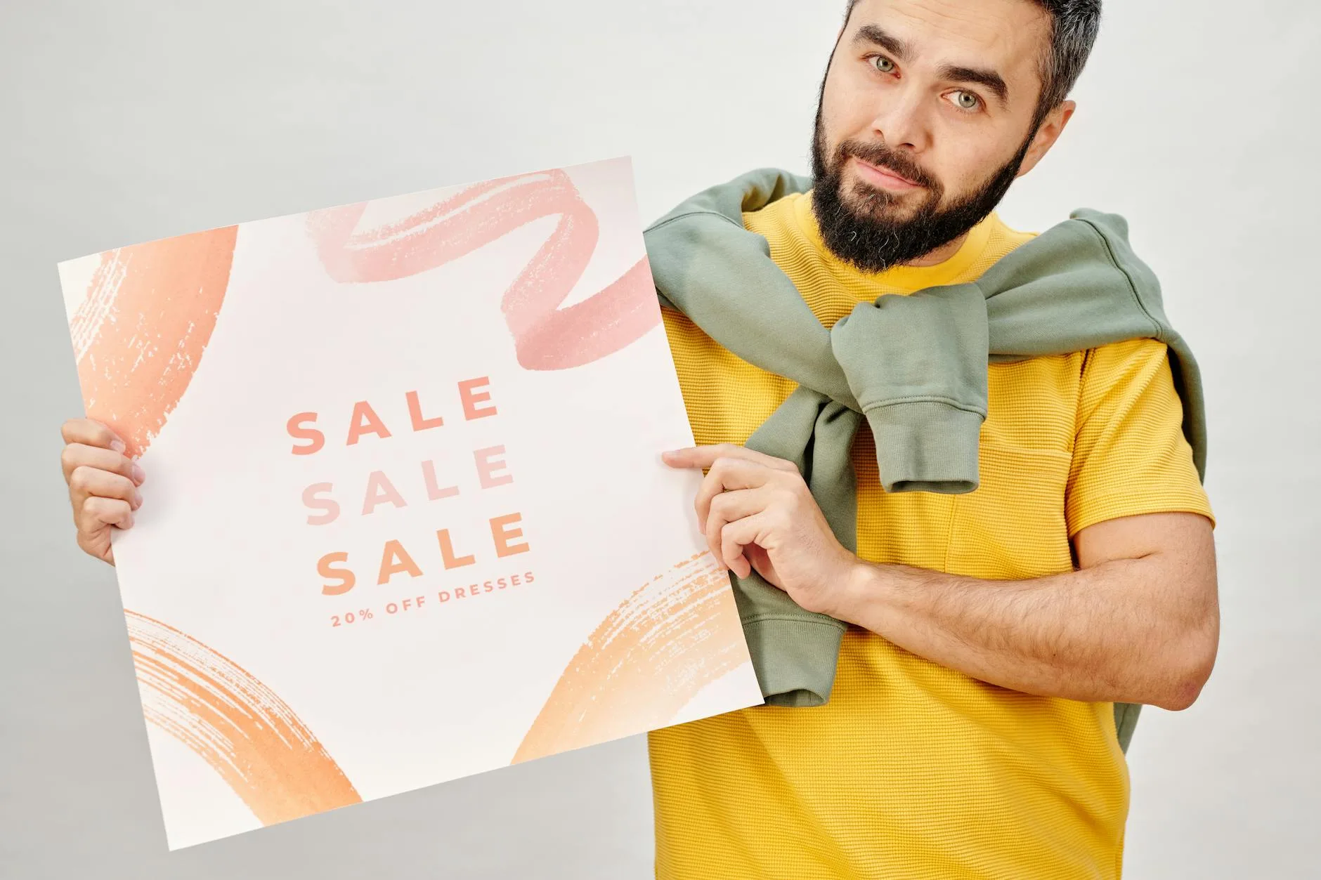 Man holding a sale poster advertising 20% off dresses. Perfect for Black Friday promotions.