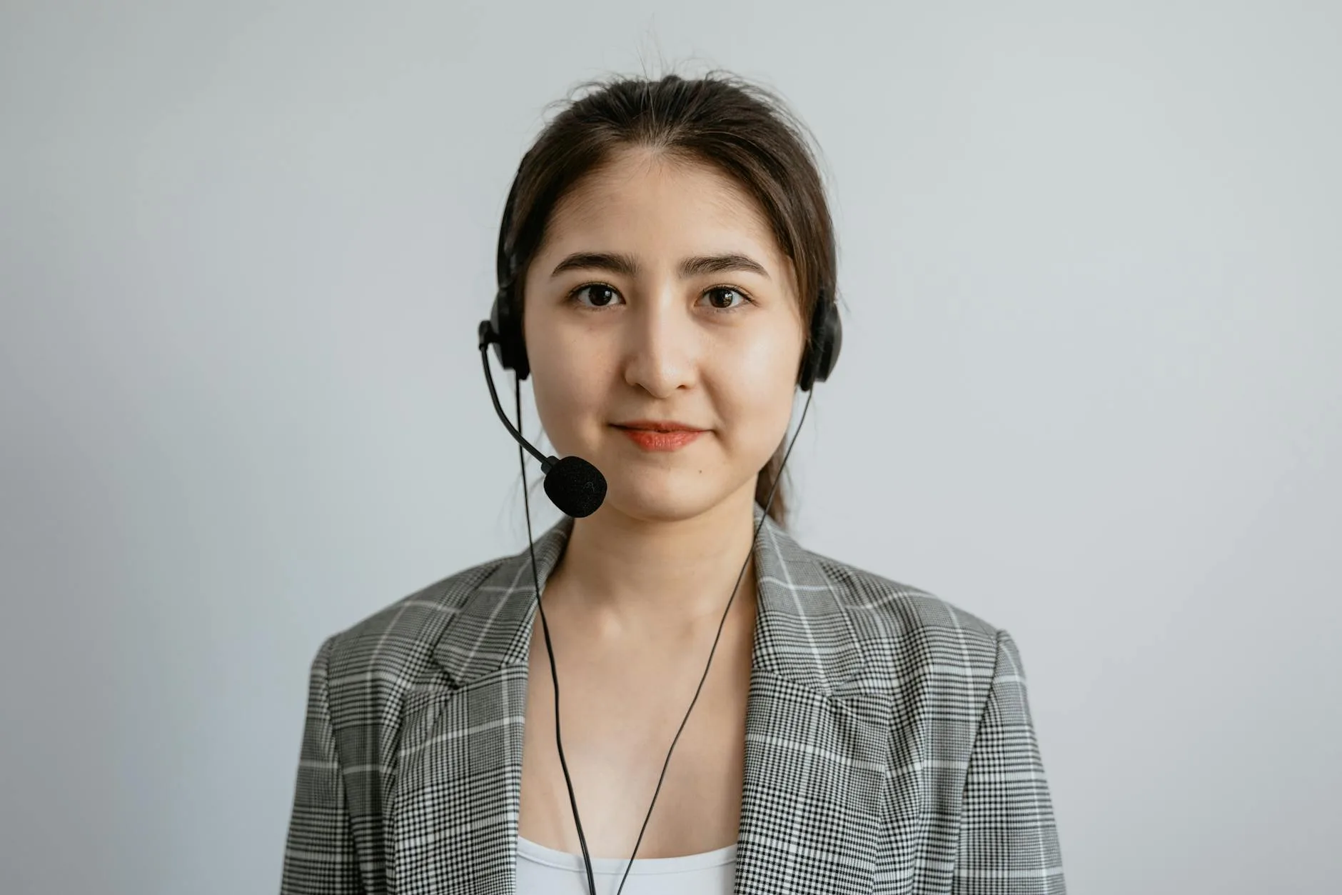 Portrait of a young female call center agent in a professional setting wearing a headset.