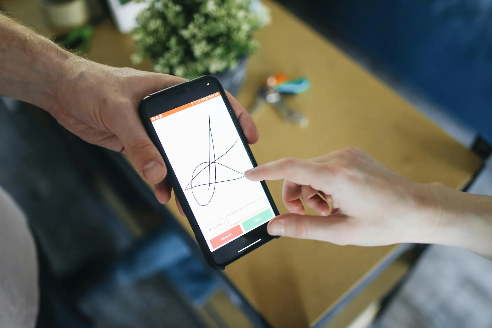 Two people completing a digital transaction with electronic signature on a smartphone screen.
