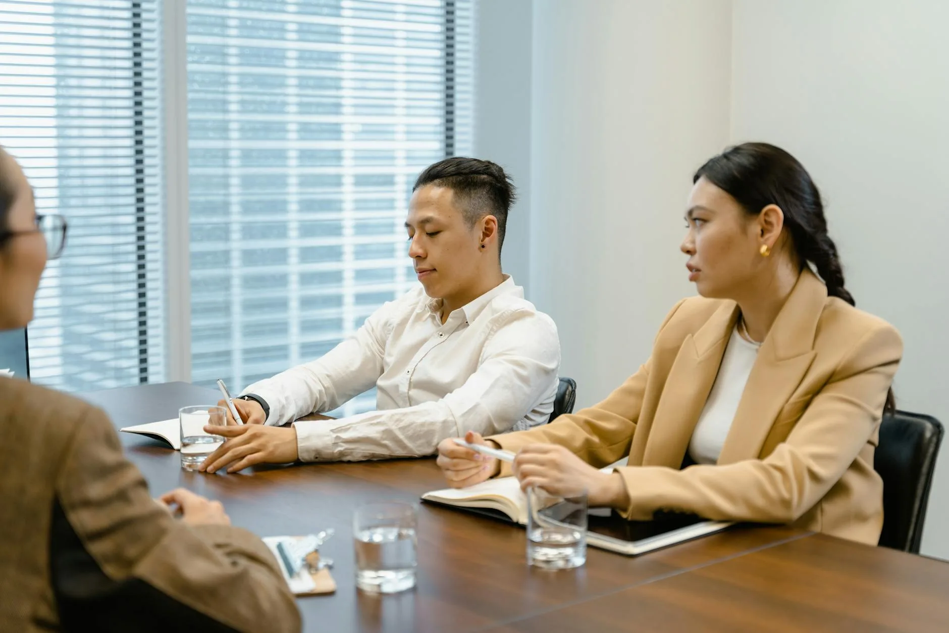 Business professionals in a meeting room discussing and taking notes. Ideal for teamwork and corporate themes.