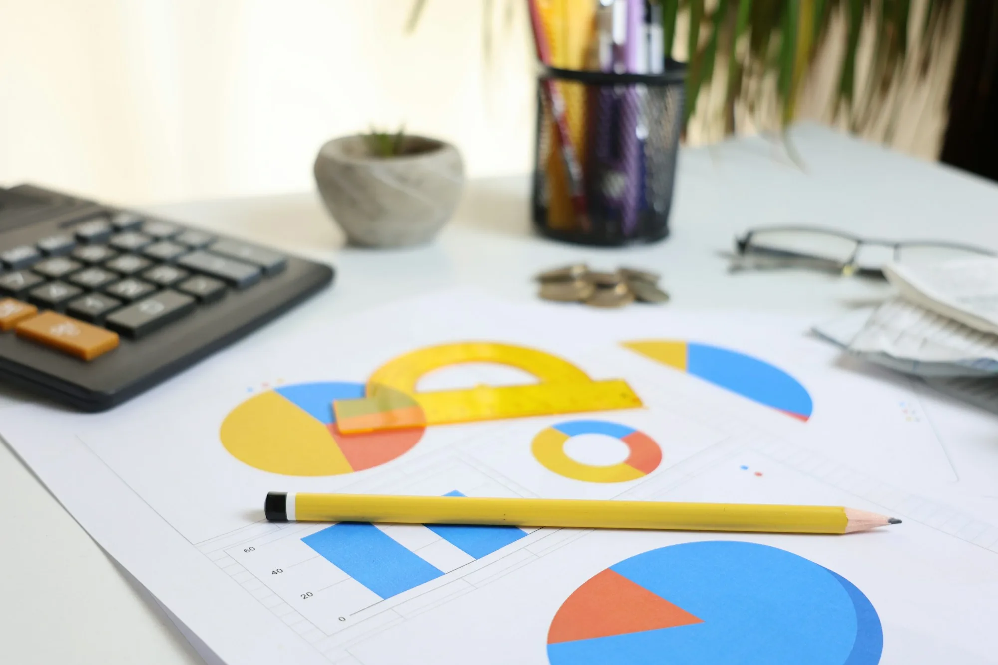 Máy tính cầm tay và biểu đồ trên bàn, minh họa cách dùng timesheet là gì để tính lợi nhuận dự án