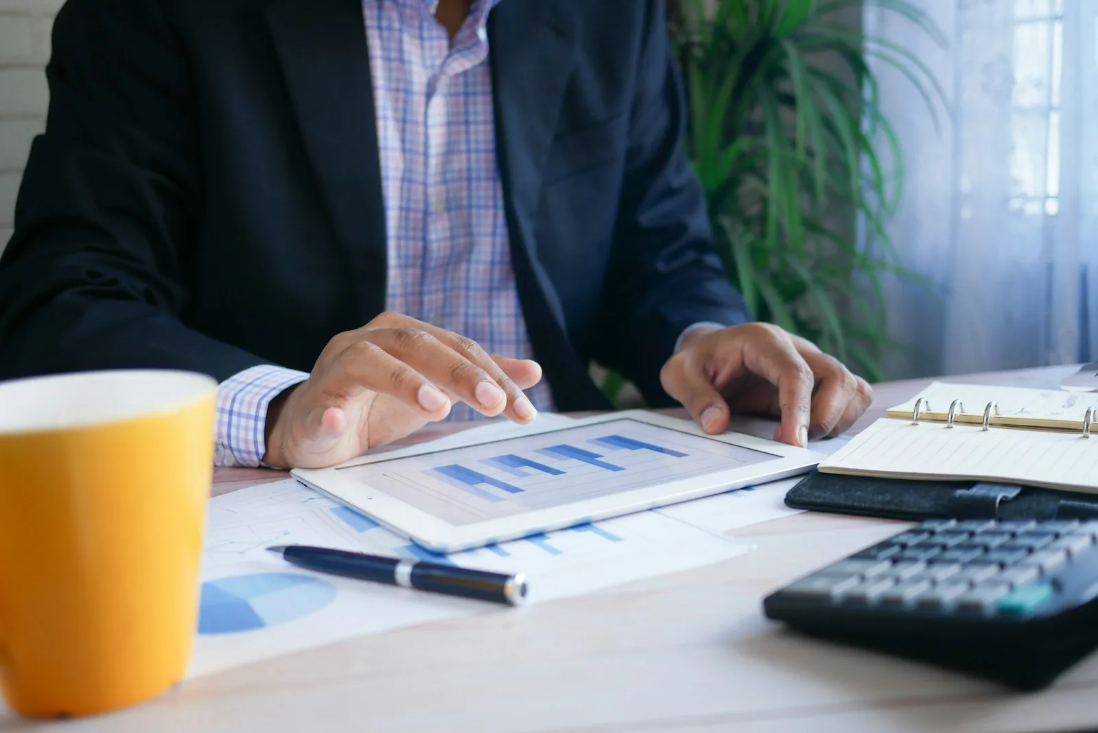 Nhân viên tín dụng xem báo cáo tài chính cùng máy tính cầm tay, bối cảnh dùng Zoho CRM cho công ty tài chính