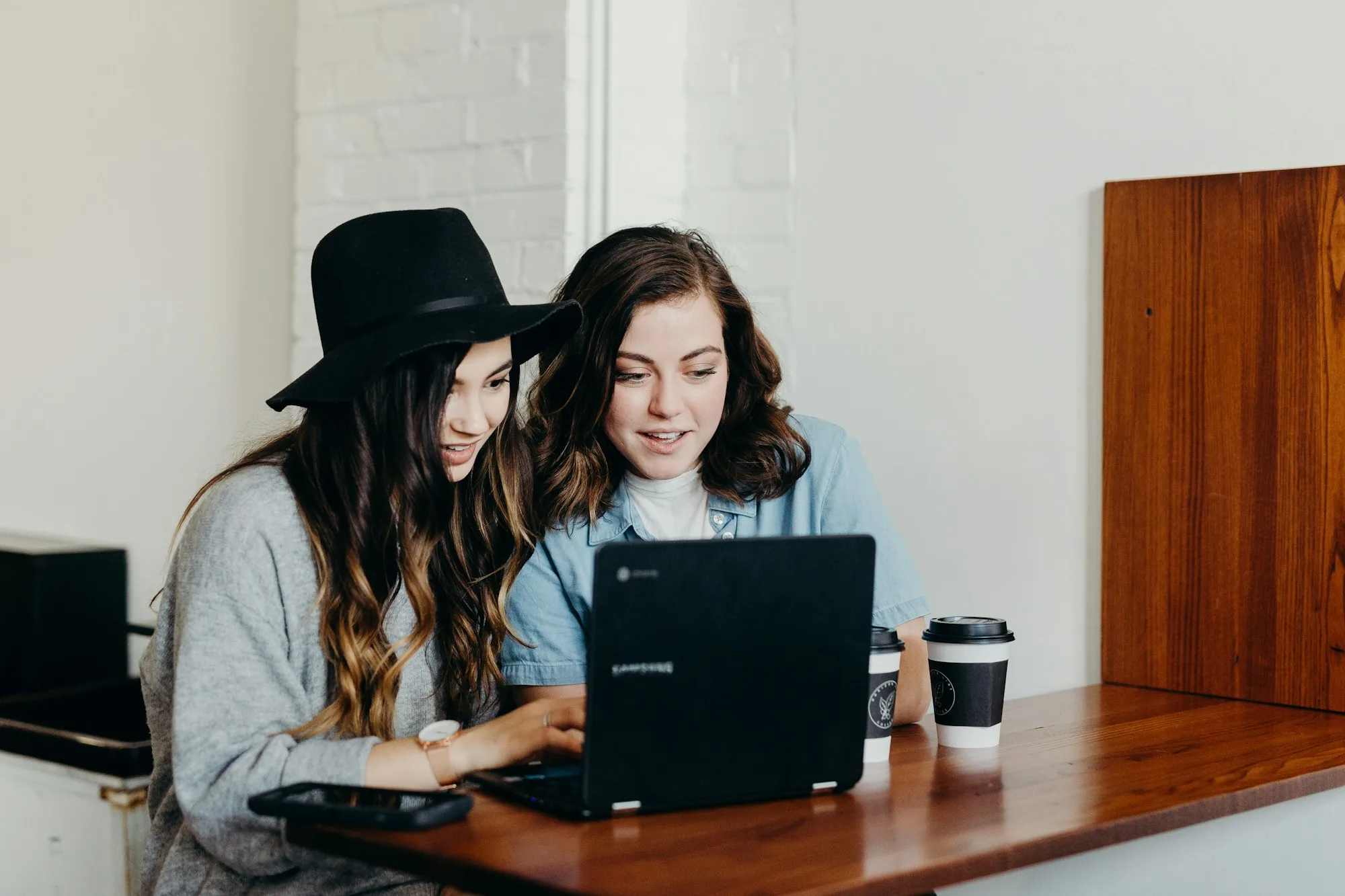 Hai người cùng đọc hội thoại live chat thu lead trên laptop trước khi chuyển sang CRM