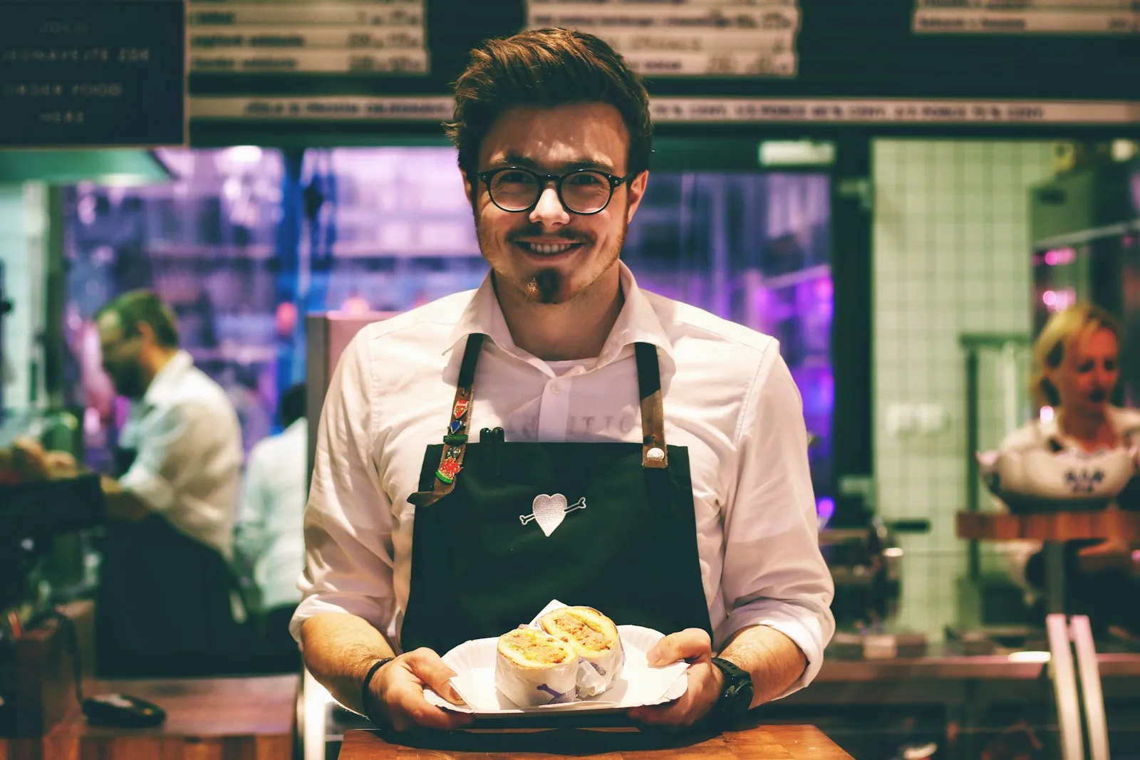 Nhân viên nhà hàng mang món ăn ra cho khách, bối cảnh case study CRM cho nhà hàng chuỗi F&B